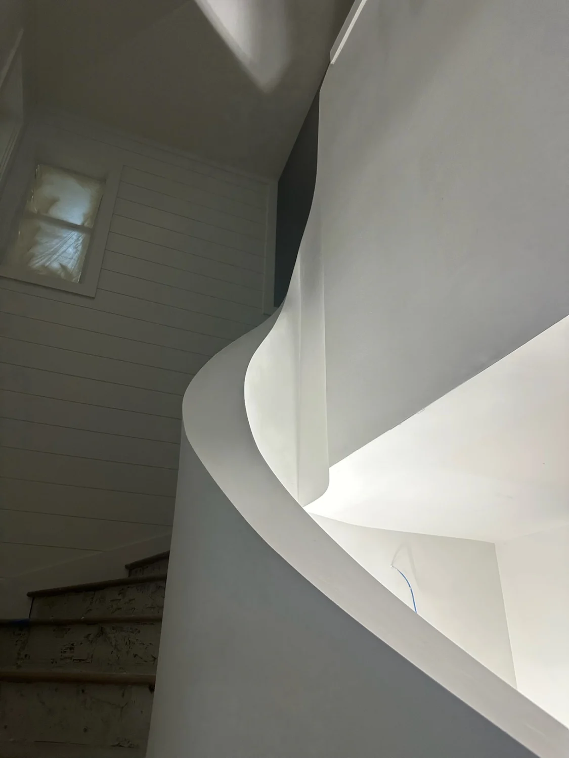 Close-up of precisely troweled spiral staircase edges and flowing drywall transitions in Sewall's Point, FL