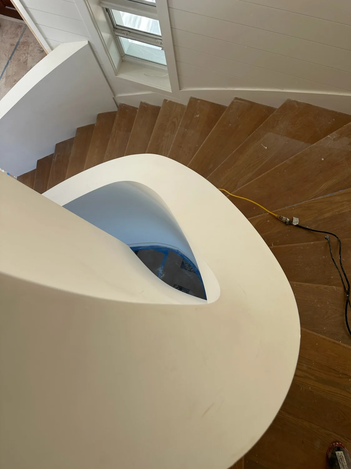 Overhead view of the spiral staircase showing smooth curved drywall walls and precise edges in Sewall's Point, FL