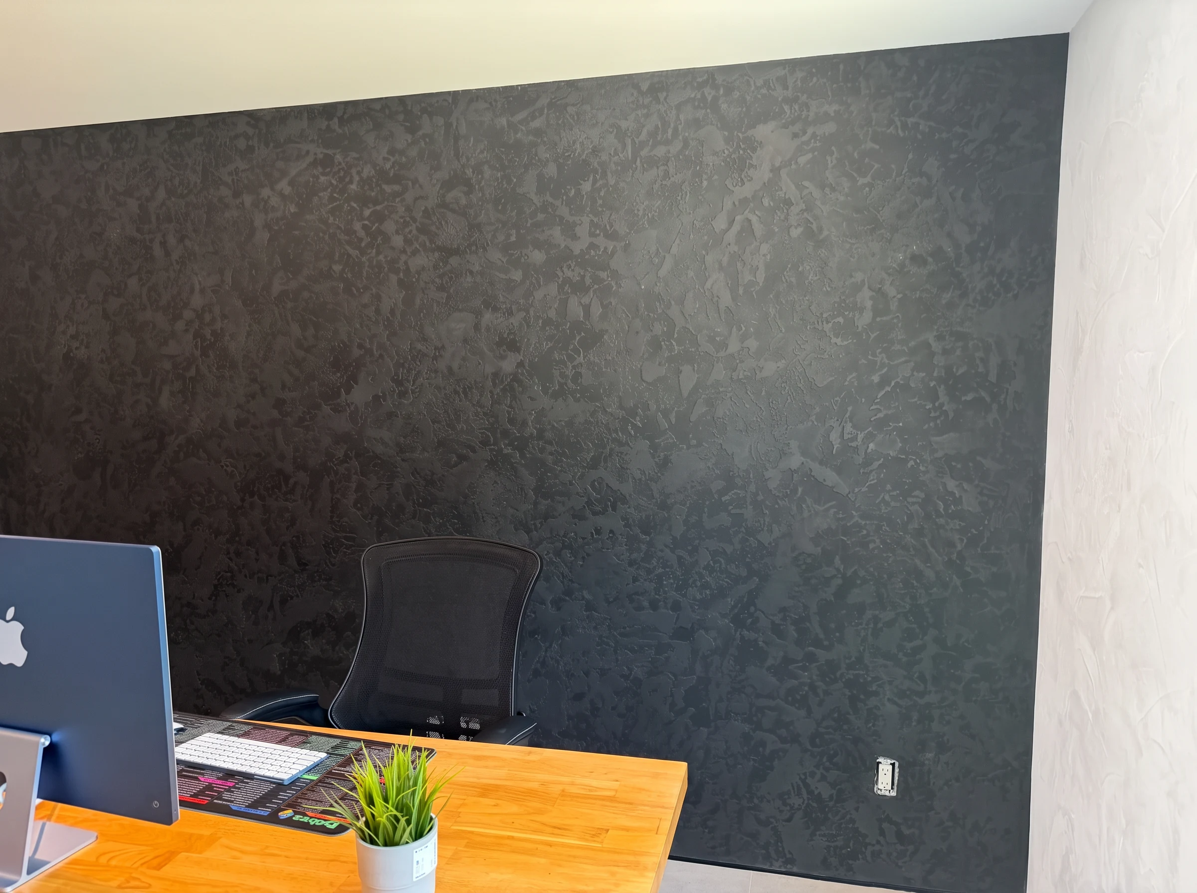 Wide view of the textured black Venetian plaster home office accent wall in Palm Beach Gardens, Florida